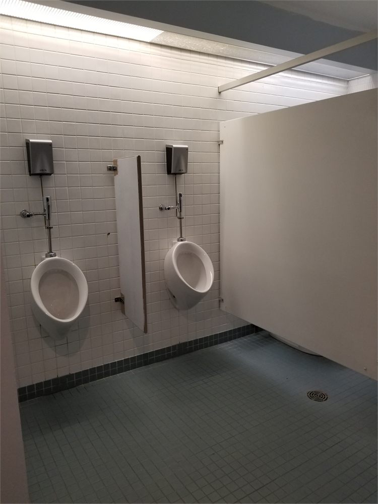 Commercial washroom with white partitions before painting
