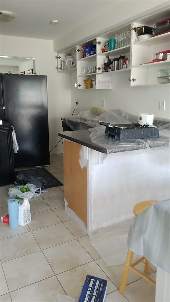 Kitchen cabinets masked and primed partway through refinishing