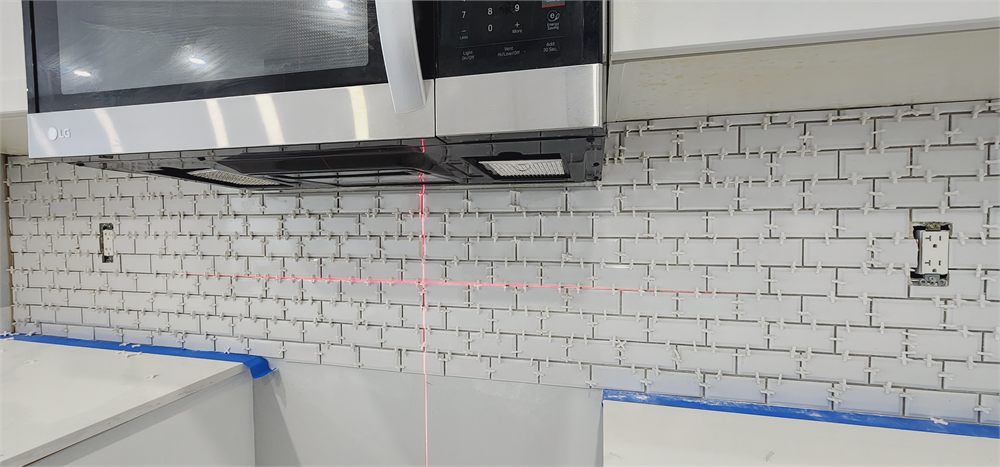 White subway tile backsplash set with spacers under the range microwave