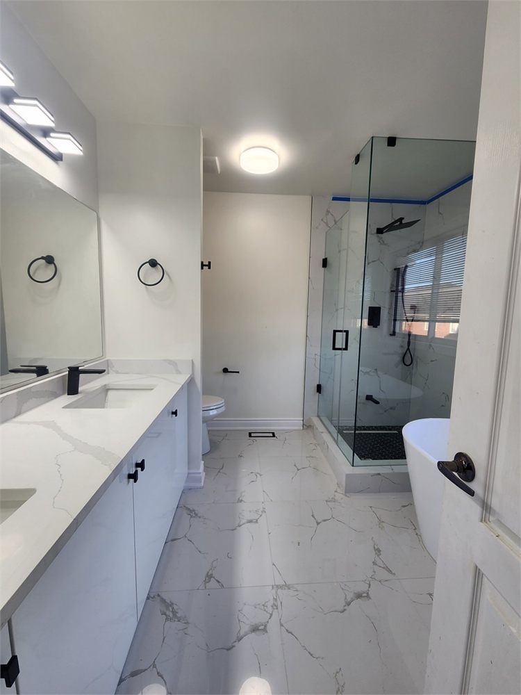 Ensuite with marble-look porcelain floor, glass corner shower and freestanding tub