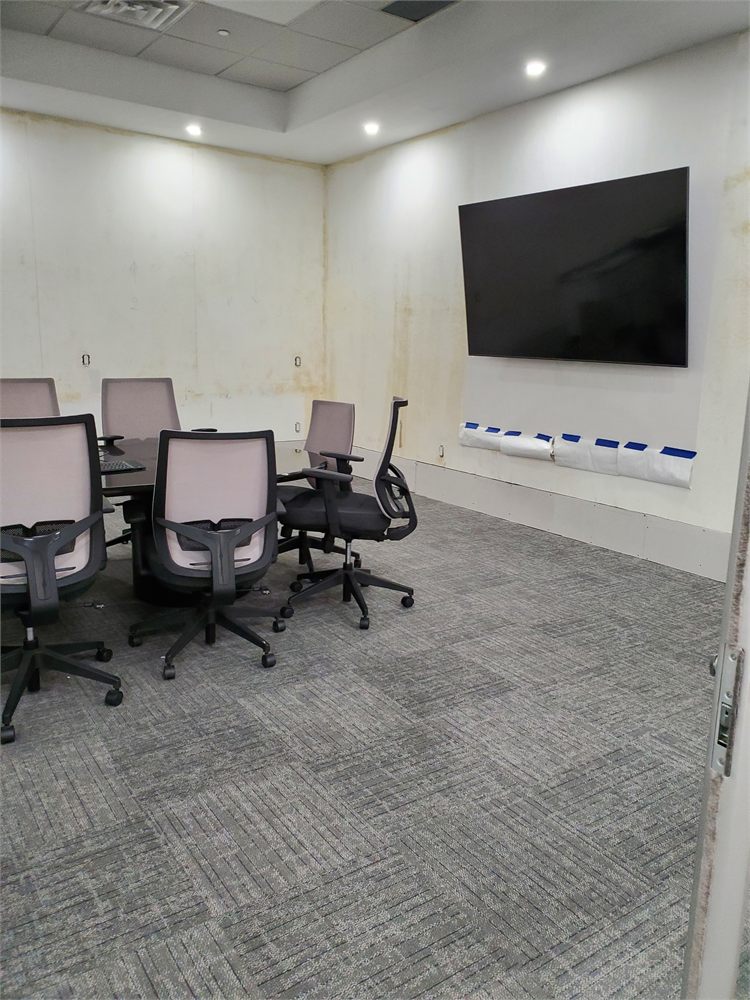 Meeting room walls with water stains before the drywall repair